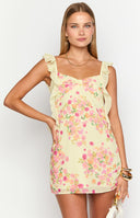 girl wearing a yellow floral mini dress with ruffle detailed straps